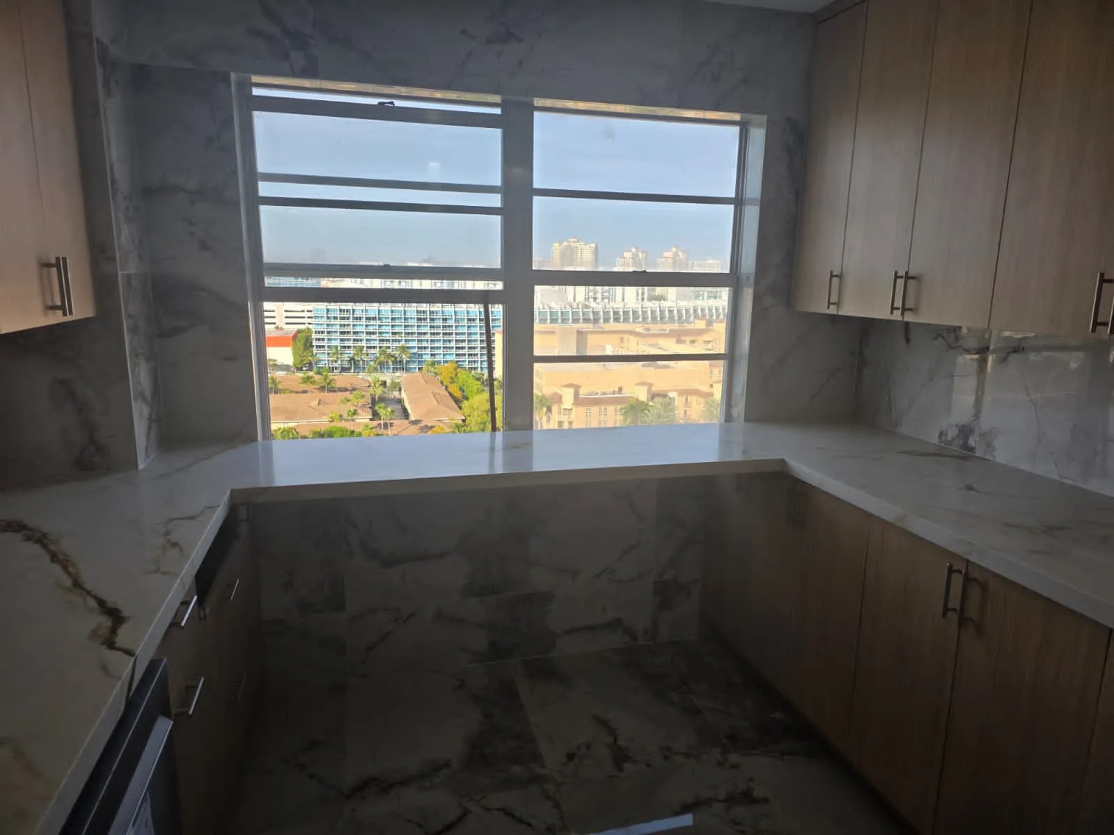 Oak kitchen with dramatic marble counters and city view